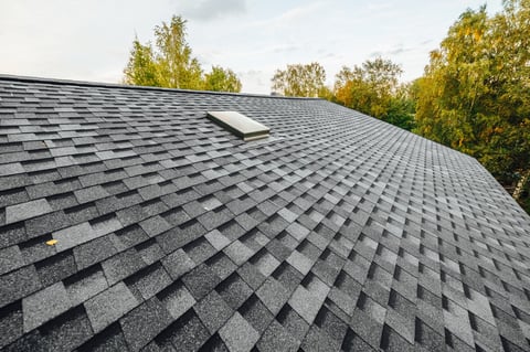 New house roof with shingles and ventilation window